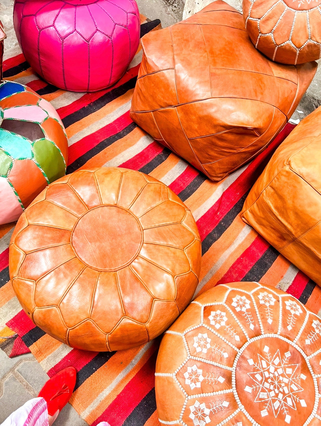 Hand-stitched round Moroccan leather pouf in natural tan, perfect as an ottoman or extra seating.
