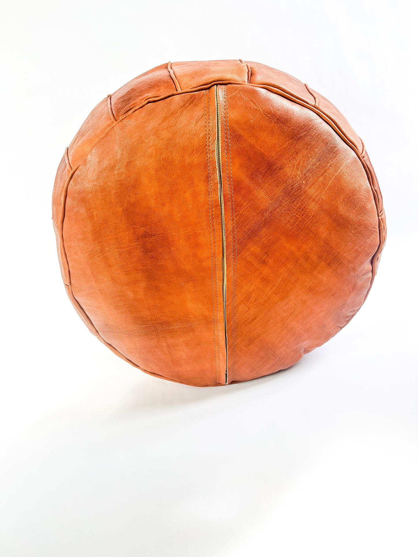 Hand-stitched round Moroccan leather pouf in natural tan, perfect as an ottoman or extra seating.